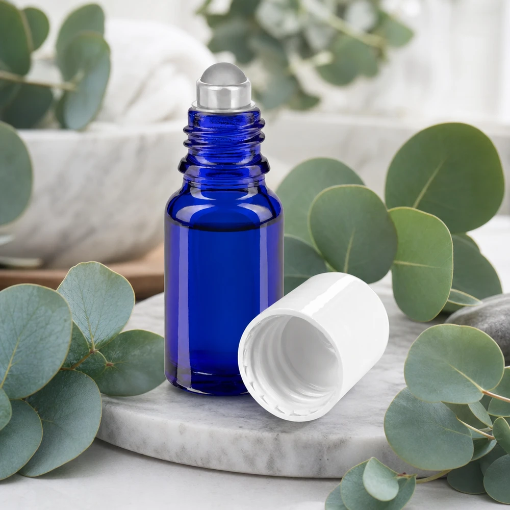 Flacone roll-on in vetro da farmacia da 10 ml, colore blu cobalto, con sfera rotante in acciaio inossidabile e tappo bianco su fondo marmorizzato