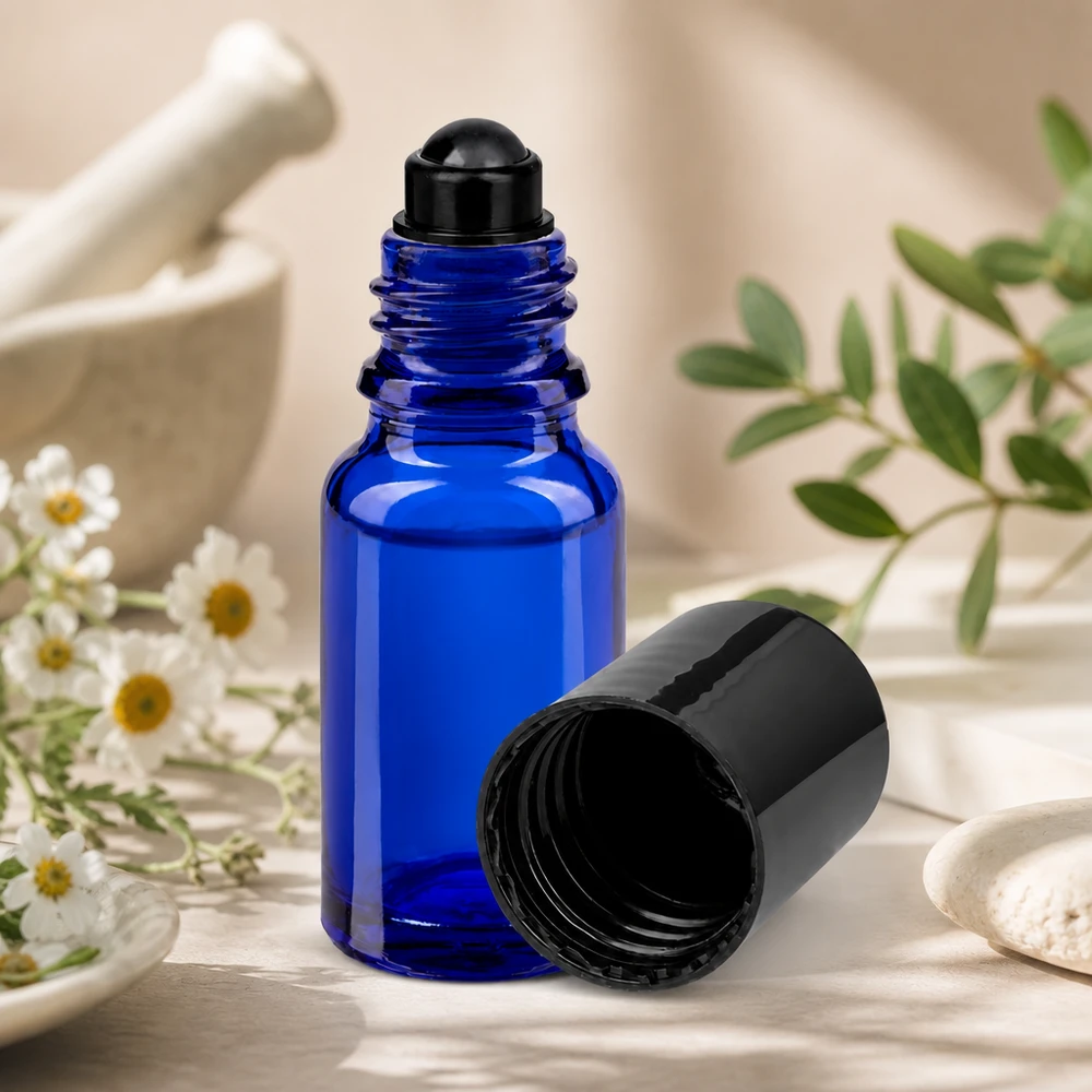Flacone per deodorante stick in vetro blu 10 ml, roll-on vuoto Flacone roll-on blu da 10 ml STD con tappo nero accanto a erbe da mortaio e fiori di camomilla