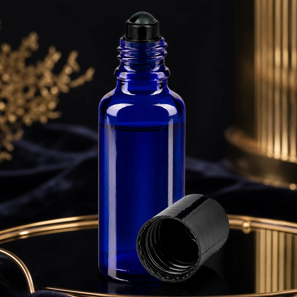 Flacone per deodorante stick in vetro blu 30 ml, roll-on vuoto Flacone roll-on blu da 30 ml con tappo a vite nero aperto su un vassoio dorato