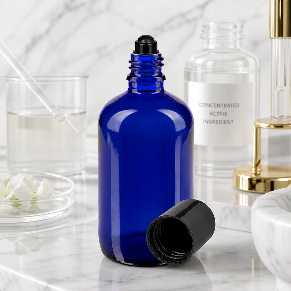 Flacone roll-on da 100 ml aperto, di colore blu cobalto con applicatore a sfera nero, in un ambiente di laboratorio