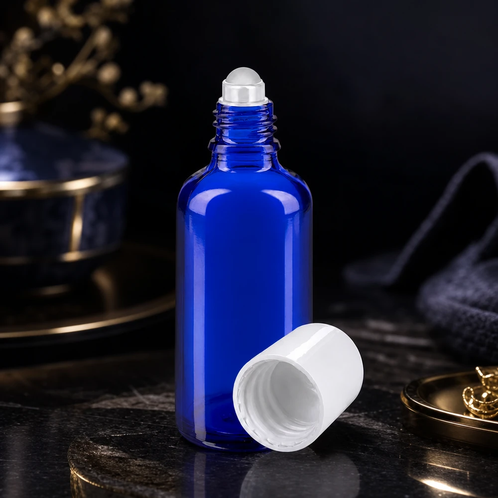 Flacone di vetro da farmacia blu da 50 ml aperto, con tappo a sfera bianco, su una superficie di marmo scuro