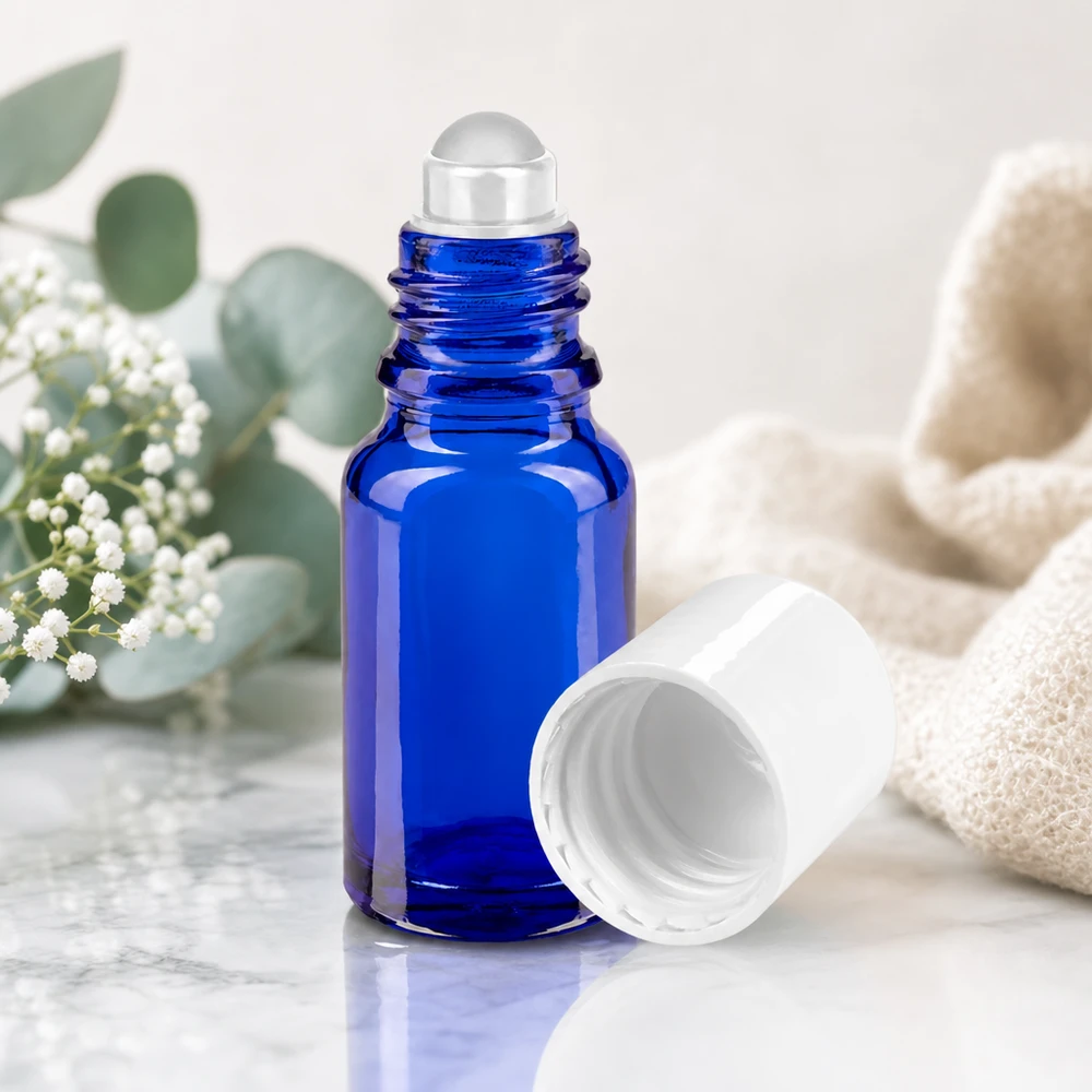 Flacone roll-on in vetro da farmacia da 10 ml, blu cobalto, con sfera di vetro trasparente su fondo marmorizzato